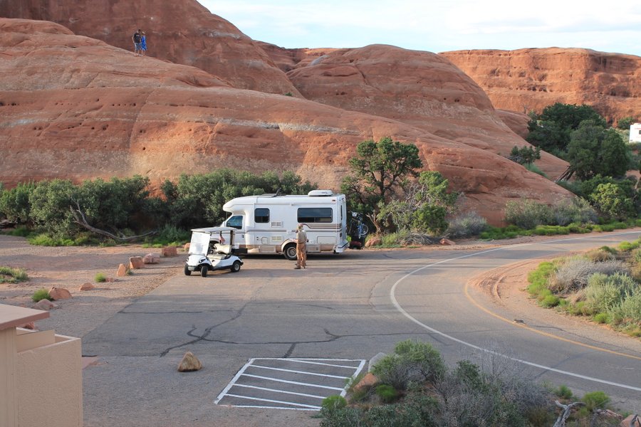 Our little RV parked at the Arches Campground. Randall and the Ranger are discussing the terms of our use of the group parking area.