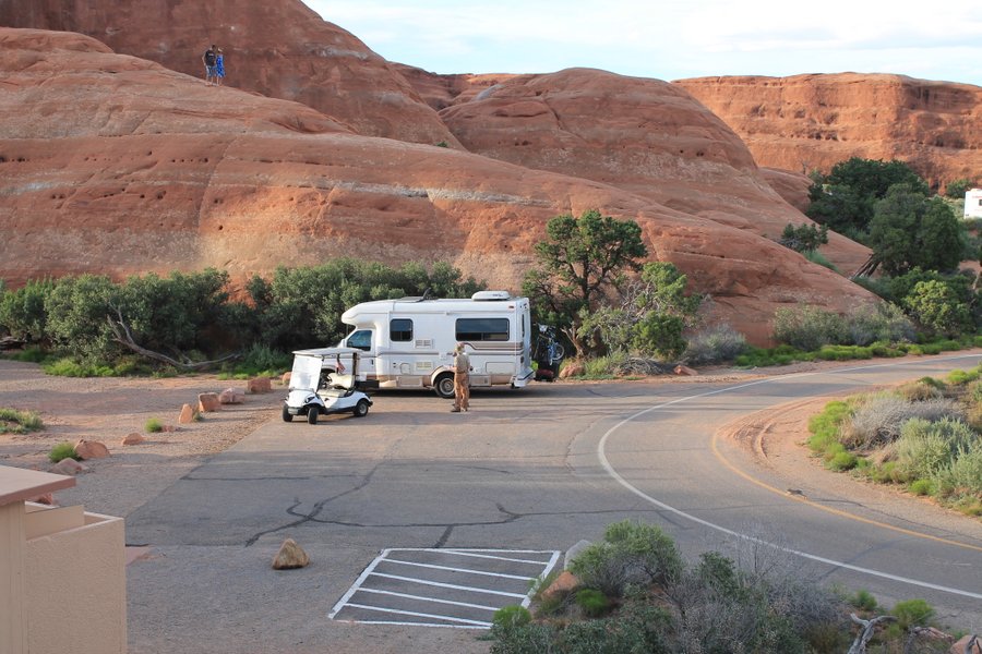 Our little  RV parked at the Arches Campground. Randall and the Ranger are discussing the terms of our use of the group parking area.