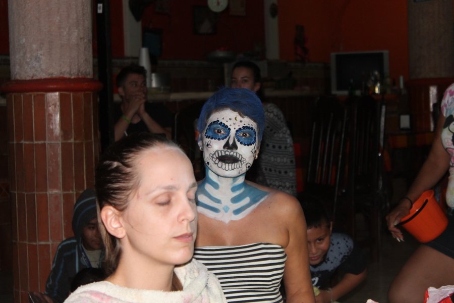 The lady in the foreground is sitting to get her face painted while the one in back just got all finished up.